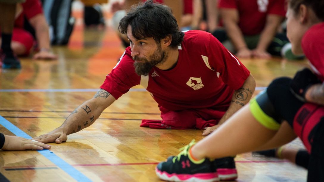 U.S. Marine Corps Cpl. Raymond Hennagir reaches forward during the 2015 Department of Defense Warrior Games sitting volleyball at Marine Corps Base Quantico, Virginia, June 19-28, 2015. The Warrior Games, founded in 2010, is a Paralympic-style competition that features eight adaptive sports for wounded, ill, and injured service members and veterans from the U.S. Army, Marine Corp, Navy/Coast Guard, Air Force, Special Operations Command, and the British Armed Forces. This year marks the first time the DoD takes responsibility for operational planning and coordination of the event, in which approximately 250 athletes are expected to compete. 
