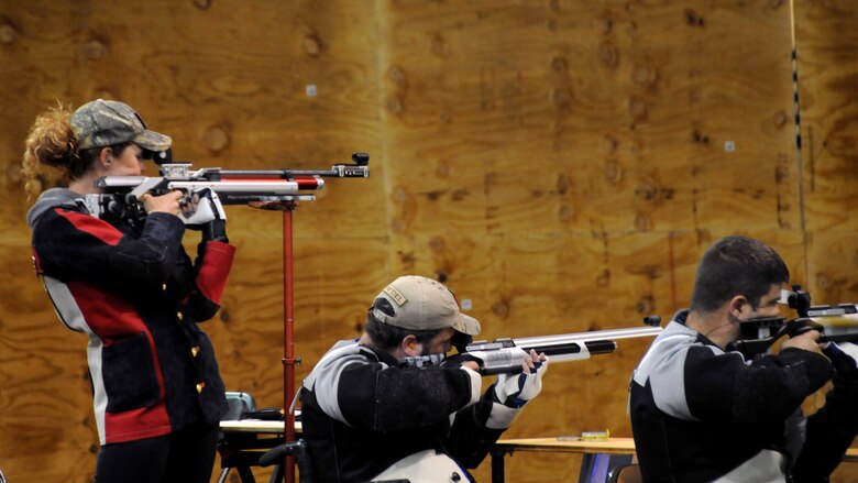 Medically retired Marine Sgt. Janae Piper, Air Force Staff Sgt. Seth Pena and Air Force Master Sgt. Daniel Waugh get ready to compete in the air rifle competition at the 2015 DoD Warrior Games at Marine Corps Base Quantico, Virginia, June 26, 2015. Piper earned the gold medal, Waugh earned the silver medal and Pena earned the bronze medal for the event.