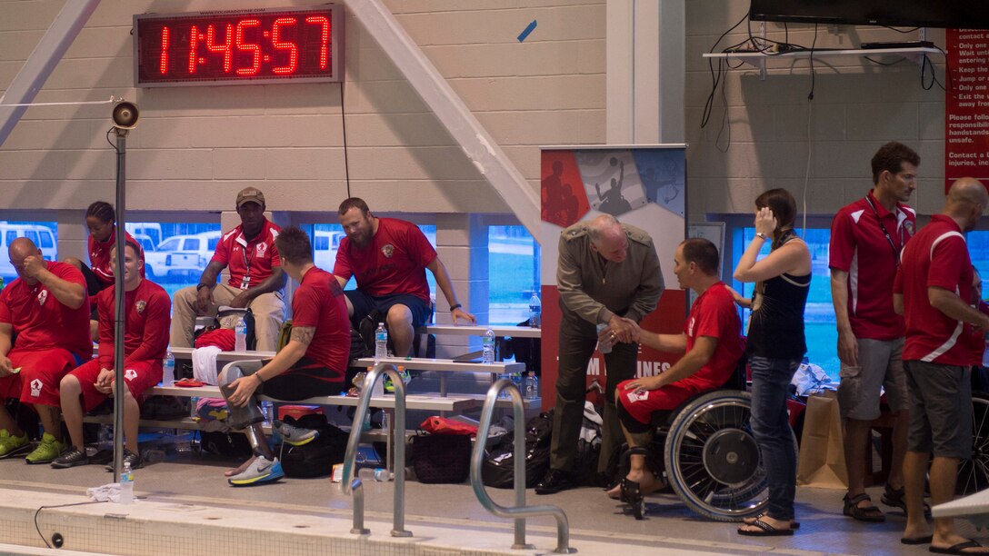 Chaplain of the U.S. Marine Corps U.S. Navy Rear Adm. Brent Scott introduces himself to a member of Team Marines during the 2015 Department of Defense Warrior Games swimming competition at Freedom Aquatics, Manassas, Virginia, June 27, 2015. The Warrior Games, founded in 2010, is a Paralympic-style competition that features eight adaptive sports for wounded, ill, and injured service members and veterans from the U.S. Army, Marine Corps, Navy/Coast Guard, Air Force, Special Operations Command, and the British Armed Forces. This year marks the first time the DoD takes responsibility for operational planning and coordination of the event, in which approximately 250 athletes are expected to compete.
