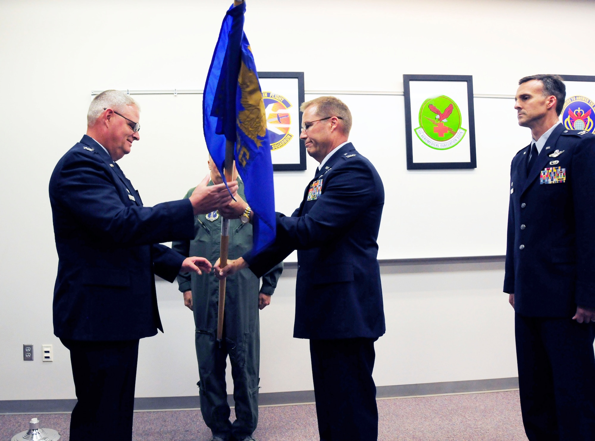 U.S. Air Force Col. Marshall C. Collins, commander, 145th Airlift Wing, receives guidon from outgoing commander, Col. Charles D. Davis III as he relinquishes command of the 145th Operations Group, during a change of command ceremony held at the North Carolina Air National Guard Base, Charlotte Douglas International Airport; June 6, 2015. Davis, who enlisted in the military July 1977 as a Weapons Mechanic for the Arizona Air National Guard, was commissioned through the Academy of Military Science, McGhee Tyson Air National Guard Base, Knoxville, Tenn., in 1985. Col. Davis joined the NCANG in 1997 and after serving 18 years in various leadership positions, will retire August 2015. (U.S. Air National Guard photo by Master Sgt. Patricia F. Moran, 145th Public Affairs/Released)