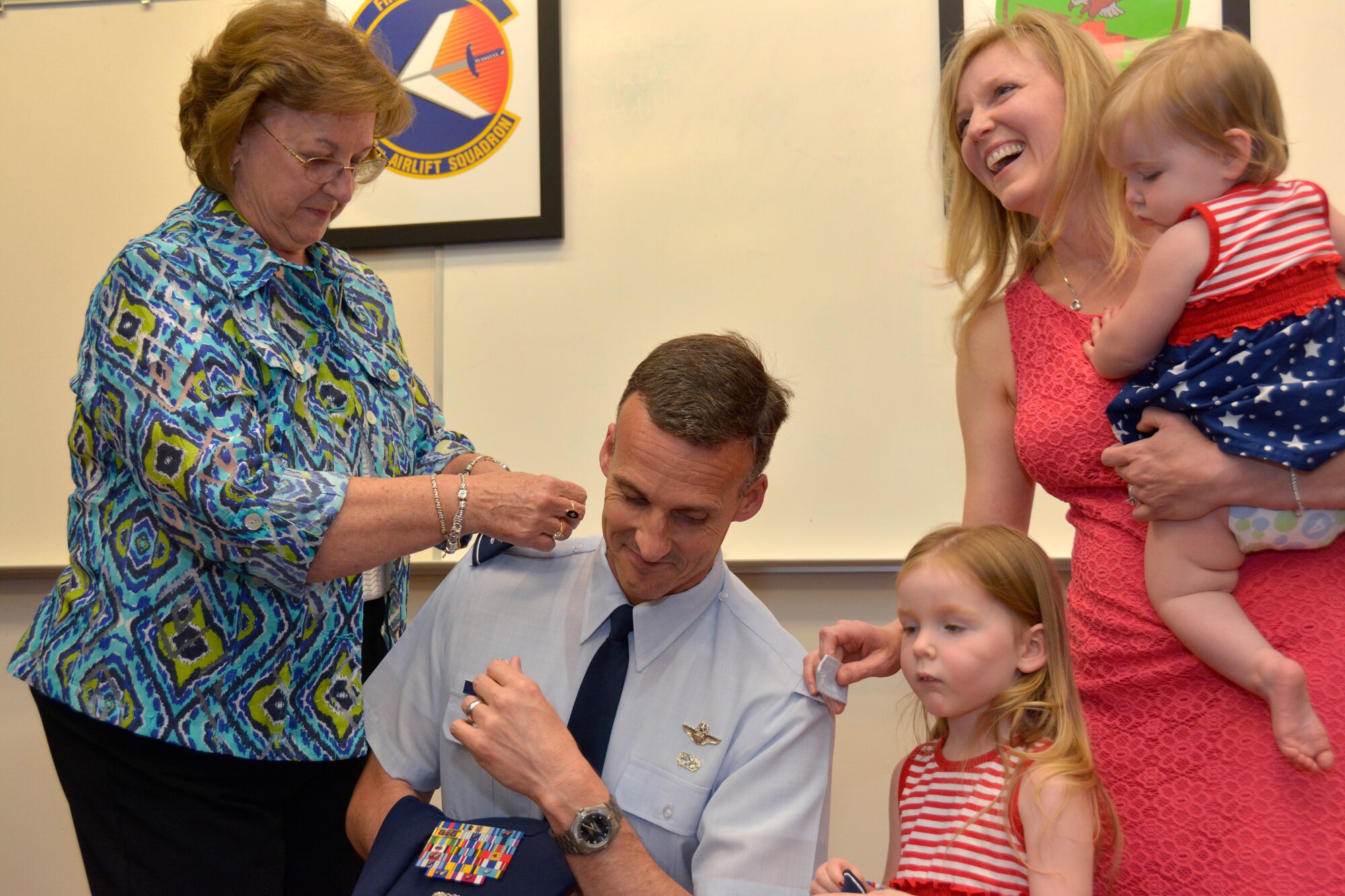 U.S. Air Force Lt. Col. Joseph H. Stepp IV, assisted mother, wife and daughters as they attached Stepp’s epaulets with his new rank of Colonel during a promotion ceremony held in his honor at the North Carolina Air National Guard Base, Charlotte Douglas International Airport, June 6, 2015. (U.S. Air National Guard photo by Senior Airman Laura Montgomery, 145th Public Affairs/Released)