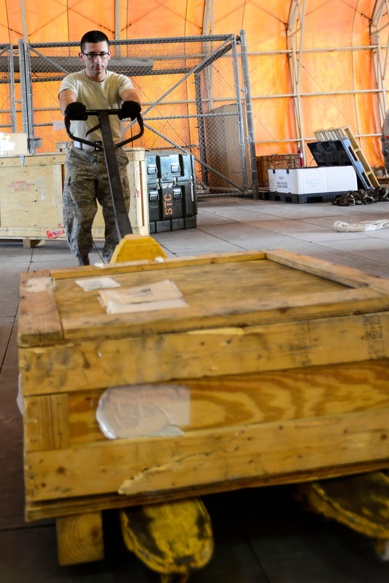 Cadet Kyle Post pushes cargo to build a pallet during a visit to an undisclosed location in Southwest Asia, June 10, 2015. Cadets are exposed to a variety of career fields during the Operation Air Force program to help them decide which job to pursue upon graduation and commissioning as a 2nd lieutenant. (U.S. Air Force photo by Senior Airman Racheal E. Watson/Released)