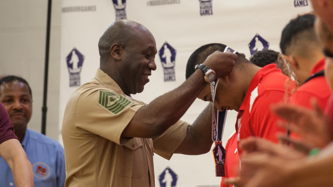 Sgt. Maj. Ronald L. Green, the 18th Sergeant Major of the Marine Corps, presents medals to the Marine Corps Sitting Volleyball Team during the Department of Defense Warrior Games at Marine Corps Base Quantico, Virginia, June 28, 2015. 