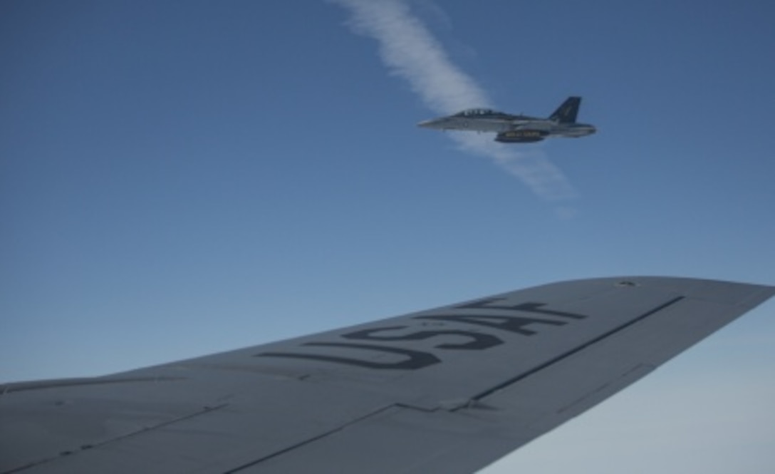 A U.S. Marine Corps F/A-18D Hornet aircraft, assigned to the Marine All-Weather Fighter Attack Squadron 242, 1st Marine Aircraft Wing, flies next to a U.S. Air Force KC-135R Stratotanker aircraft, assigned to the 459th Air Refueling Wing, Andrews Air Force Base, Md., Air Force Reserve, over the Gulf of Alaska, June 22, 2015. The aircraft was being refueled while flying a training mission during Exercise Northern Edge 15. Northern Edge is Alaska’s premier joint training exercise designed to practice operations, techniques and procedures as well as enhance interoperability among the services. Thousands of Airmen, Soldiers, Sailors, Marines and Coast Guardsmen from active duty, reserve and National Guard units are involved.