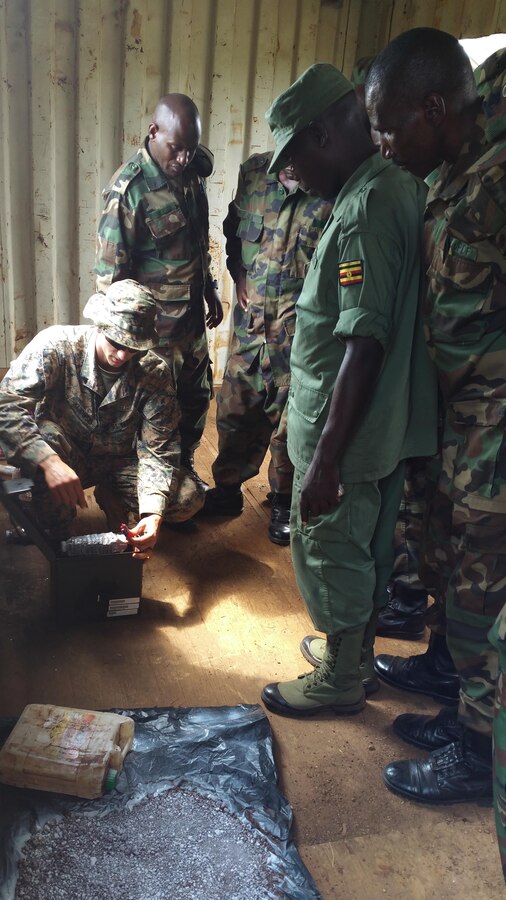 U.S. Marine Nicholas Kijowski, an explosive ordnance disposal technician, explains how to identify a homemade explosive device to Soldiers of the
Uganda People's Defense Force at Camp Singo, Uganda, Feb. 25, 2015. More than 20 U.S. Marines and Sailors with Special-Purpose Marine Air-Ground Task Force Crisis Response-Africa trained with Ugandan Soldiers during a three-month mission, which allowed the UPDF to increase mission-specific capabilities in logistics and engineering for upcoming deployments throughout Africa. (Courtesy Photo/Released)