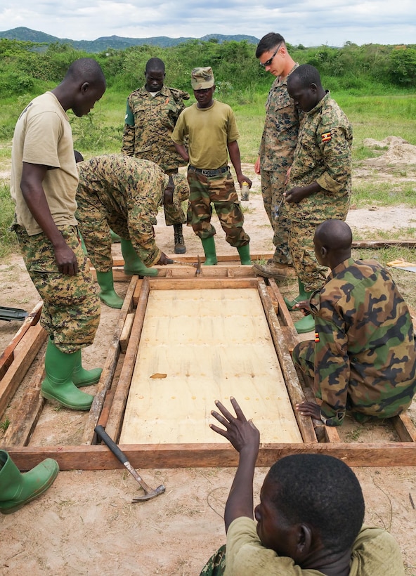 U.S. Marine Cpl. Corey McDaniel, a combat engineer, and Ugandan Soldiers frame a door during construction training at Camp Singo, Uganda, March 2, 2015. More than 20 U.S. Marines and Sailors with Special-Purpose Marine Air-Ground Task Force Crisis Response-Africa trained with Ugandan Soldiers during a three-month mission, which allowed the UPDF to increase mission-specific capabilities in logistics and engineering for upcoming deployments throughout Africa. (Courtesy Photo/Released)