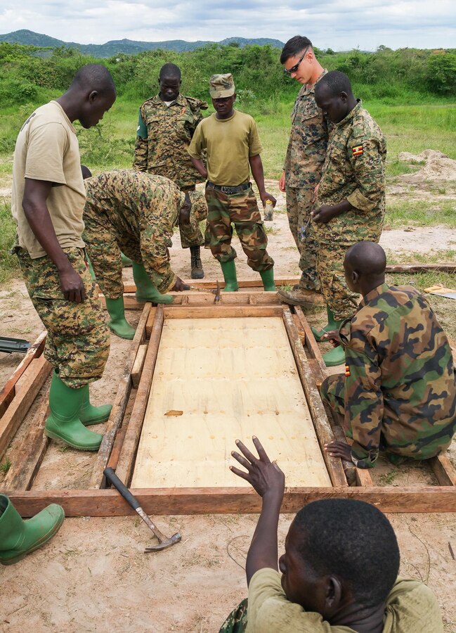 U.S. Marine Cpl. Corey McDaniel, a combat engineer, and Ugandan Soldiers frame a door during construction training at Camp Singo, Uganda, March 2, 2015. More than 20 U.S. Marines and Sailors with Special-Purpose Marine Air-Ground Task Force Crisis Response-Africa trained with Ugandan Soldiers during a three-month mission, which allowed the UPDF to increase mission-specific capabilities in logistics and engineering for upcoming deployments throughout Africa. (Courtesy Photo/Released)