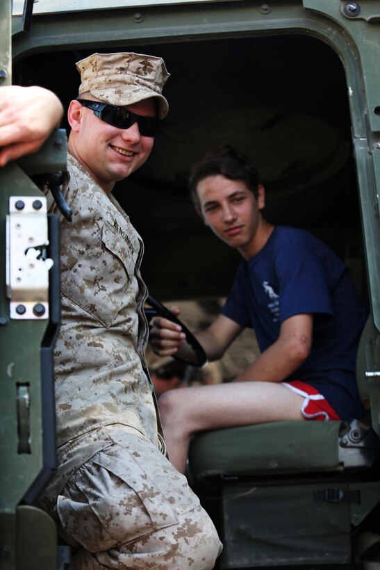 U.S. Marine Lance Cpl. Ryan Kensinger, with Black Sea Rotational Force, shows a Romanian teenager a U.S. Marine Corps Seven-Ton during a local town celebration in Ovidiu, Romania, May 31, 2015. The event gave the local community a chance to engage with the Marines who are deployed to Mihail Kogalniceanu with Black Sea Rotational Force and view some of the equipment at a static display.  (Official U.S. Marine Corps photo by 1st Lt. Sarah E. Burns)