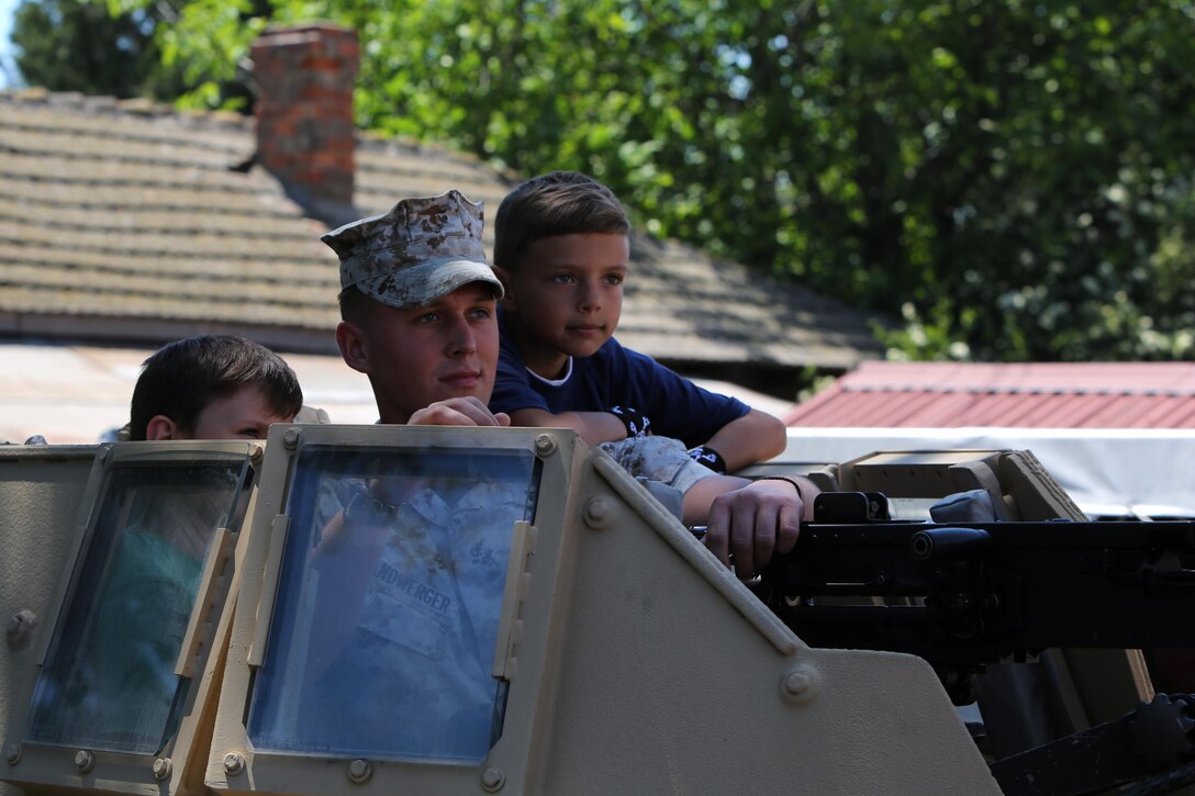 Local Romanian boys check out the turret of a Humvee with the help of U.S. Marine Lance Cpl. Luke Handwerger, with Black Sea Rotational Force, May 31, 2015. U.S. Marines with Black Sea Rotational Force and service members from the Romanian Army volunteered at the Ovidiu City Days event.  The event gave the local community a chance to engage with the Marines and view some of the equipment at a static display. (Official U.S. Marine Corps photo by 1st Lt. Sarah E. Burns)