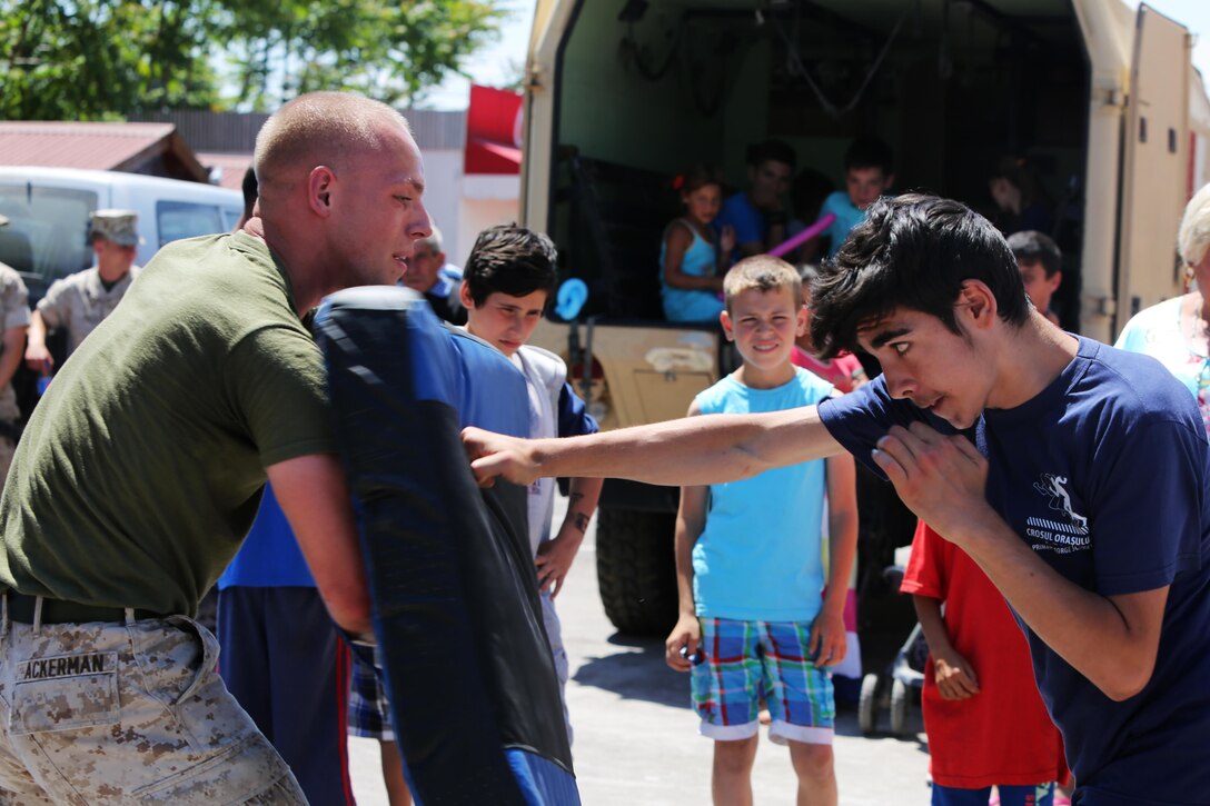 U.S. Marine Cpl. Jeffrey Ackerman, with Black Sea Rotational Force, instructs a member of the community how to throw a lead-hand punch during the Marine Corps Marital Arts Program demonstration, May 31 at the Ovidiu City Days event in a town near Mihail Kogalniceanu. The Marines with BSRF are forward postured at Mihail Kogalniceanu as part of a contingent of Marines and sailors in the Black Sea, Balkans, and Caucasus regions that maintain proven partnerships, build military capacity, promote regional security, and provide the capability for rapid crisis response as directed by U.S. European Command and U.S. Marine Corps Forces Europe and Africa. (Official U.S. Marine Corps photo by 1st Lt. Sarah E. Burns)