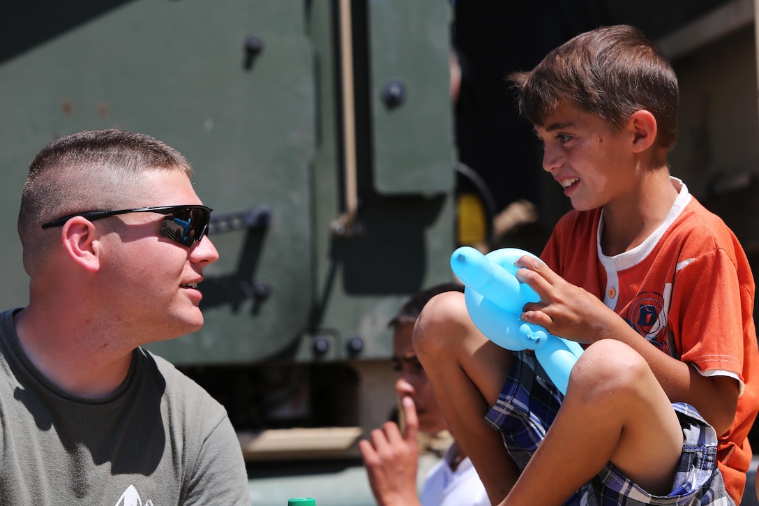 U. S. Navy Hospital Corpsman Tyler Yeager, with Black Sea Rotational Force, talks with a Romanian boy during Ovidiu City Days, May 31. U.S. Marines with Black Sea Rotational Force and service members from the Romanian Army volunteered at the event held to commemorate the town’s anniversary and celebrate National Children's’ Day in Romania. (Official U.S. Marine Corps photo by 1st Lt. Sarah E. Burns)