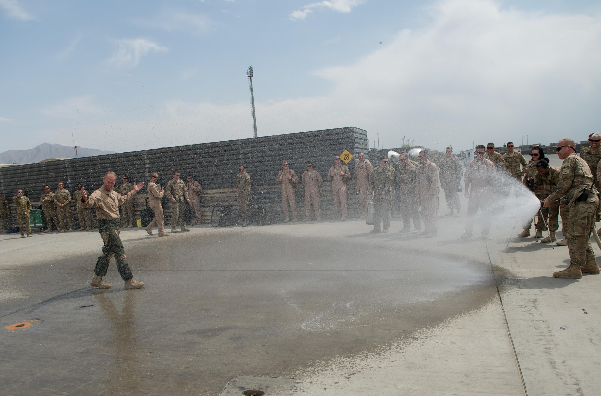 U.S. Air Force Brig. Gen. Mark D. Kelly, 455th Air Expeditionary Wing commander, is sprayed down with a water hose after his final flight as the 455th AEW Commander at Bagram Airfield, Afghanistan, June 28, 2015 The final flight is an aviation tradition in which aircrew members, upon completion of their last flight with the wing, or "fini flight," are met and hosed down with water. (U.S. Air Force photo by Tech. Sgt. Joseph Swafford/Released)