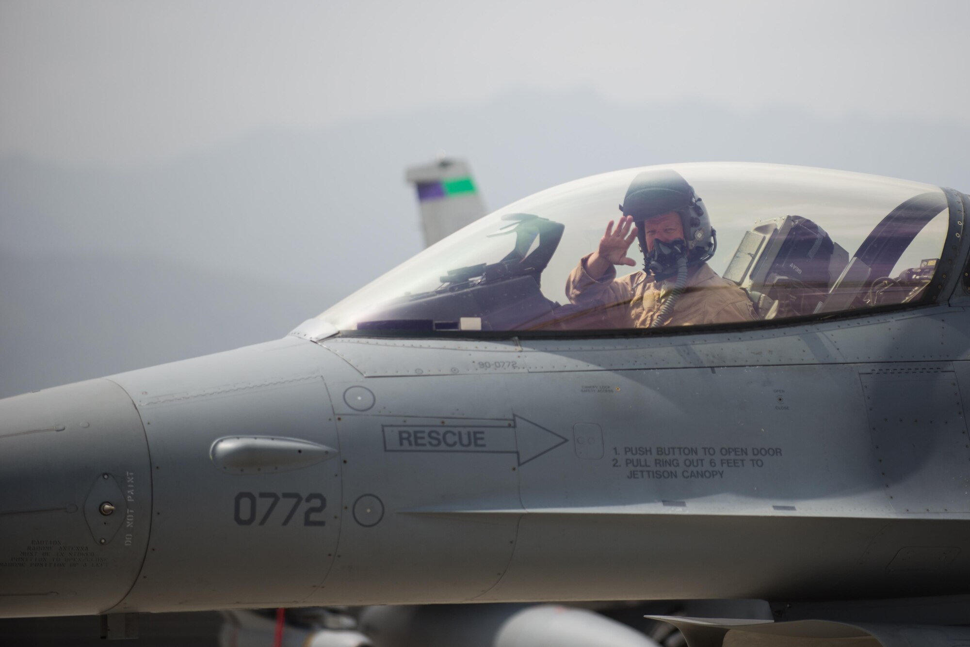 U.S. Air Force Brig. Gen. Mark D. Kelly, 455th Air Expeditionary Wing commander, waves while taxing in an F-16 Fighting Falcon aircraft during his final flight as the 455th AEW Commander at Bagram Airfield, Afghanistan, June 28, 2015 The final flight is an aviation tradition in which aircrew members, upon completion of their last flight with the wing, or "fini flight," are met and hosed down with water. (U.S. Air Force photo by Tech. Sgt. Joseph Swafford/Released)