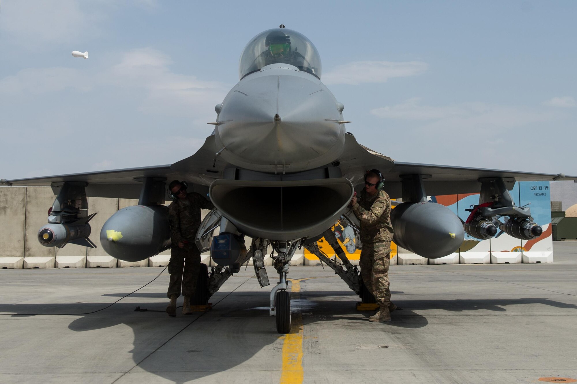 U.S. Airmen assigned to the 455th Expeditionary Aircraft Maintenance Squadron perform post flight checks while Brig. Gen. Mark D. Kelly, 455th Air Expeditionary Wing commander, prepares to exit an F-16 Fighting Falcon aircraft after his final flight as the 455th AEW Commander at Bagram Airfield, Afghanistan, June 28, 2015 The final flight is an aviation tradition in which aircrew members, upon completion of their last flight with the wing, or "fini flight," are met and hosed down with water. (U.S. Air Force photo by Tech. Sgt. Joseph Swafford/Released)