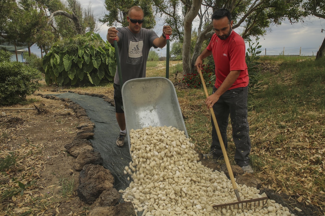 Hospitalman 2nd Class Francesco Deritis, a corpsman assigned to Special-Purpose Marine Air-Ground Task Force Crisis Response-Africa, and an Italian volunteer build a rock path at the “Colonia Don Bosco” in Catania, Italy, June 18, 2015. More than 25 service members with the unit teamed up with local residents to paint, rake and construct a pathway at the campsite in preparation for the summer season, which welcomes about 800 children daily. (U.S. Marine Corps photo by Cpl. Lucas Hopkins/Released)