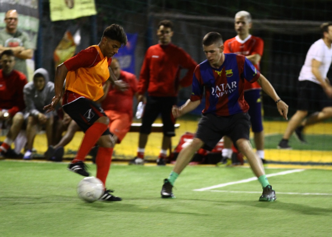 U.S. Marine Lance Cpl. Keith E. Crowley challenges an opponent during an exhibition soccer game against local Romanian children. The children are part of boys group home that falls under the Child Protective Agency of Romania. The Marines with Black Sea Rotational Force have an enduring partnership with the Child Protective Agency of Romania by giving their time during various events throughout the year. Crowley is an administrative clerk with BSRF.