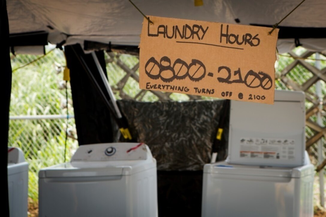 A cardboard sign indicates the hours of operation for the laundry facility at a Cooperative Security Location in Libreville, Gabon, June 17, 2015. Marines and sailors stationed at Moròn Air Base, Spain, are currently validating their forward-staging capabilities while maintaining life support for approximately 200 personnel in Africa. (U.S. Marine Corps photograph by Lance Cpl. Christopher Mendoza/Released)