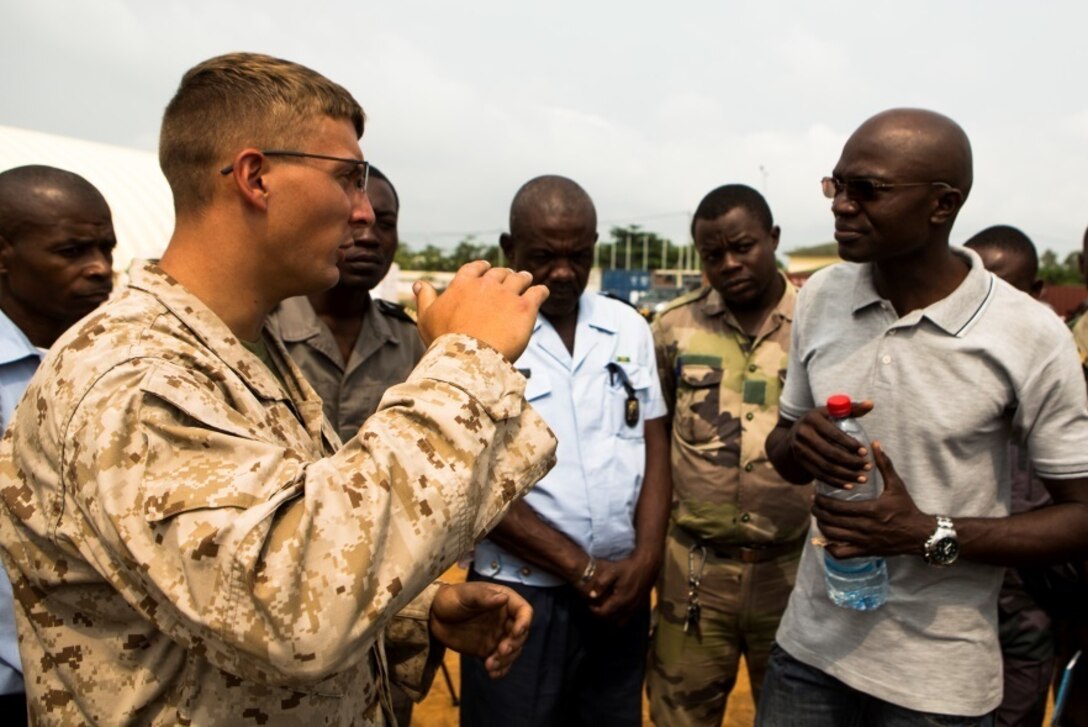 U.S. Marine Corps Lance Cpl.  Keegan Nelson, left, a generator mechanic with Special-Purpose Marine Air-Ground Task Force Crisis Response-Africa, discusses the functions of different generator components at the Marines’ Cooperative Support Location in Libreville, Gabon, June 22, 2015. Marines with SPMAGTF-CR-AF demonstrated the capabilities and functions of different generators to strengthen ties and enhance the knowledge of their partner service members. (U.S. Marine Corps photograph by Lance Cpl. Christopher Mendoza/Released)