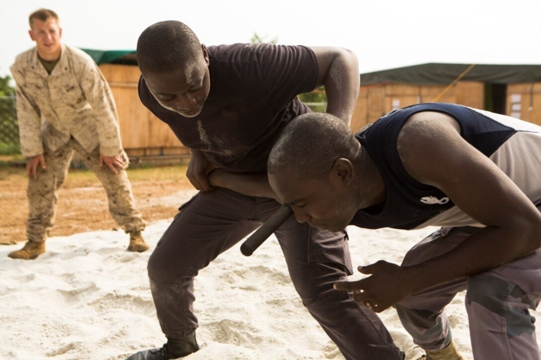 Gabonese Gendarmerie service members practice non-lethal compliance techniques at a Cooperative Security Location established by U.S. Marines with Special-Purpose Marine Air-Ground Task Force Crisis Response-Africa in Libreville, Gabon, June 24, 2015. The Gendarmerie service members first completed a physically challenging circuit course to test their ability to remain calm and put their training to the test under fatigue and stress. The Marines, who are based out of Morón Air Base, Spain, are currently validating their forward-staging capabilities aboard the CSL while building partnerships with their Gabonese counterparts. (U.S. Marine Corps photograph by Lance Cpl. Christopher Mendoza/Released)