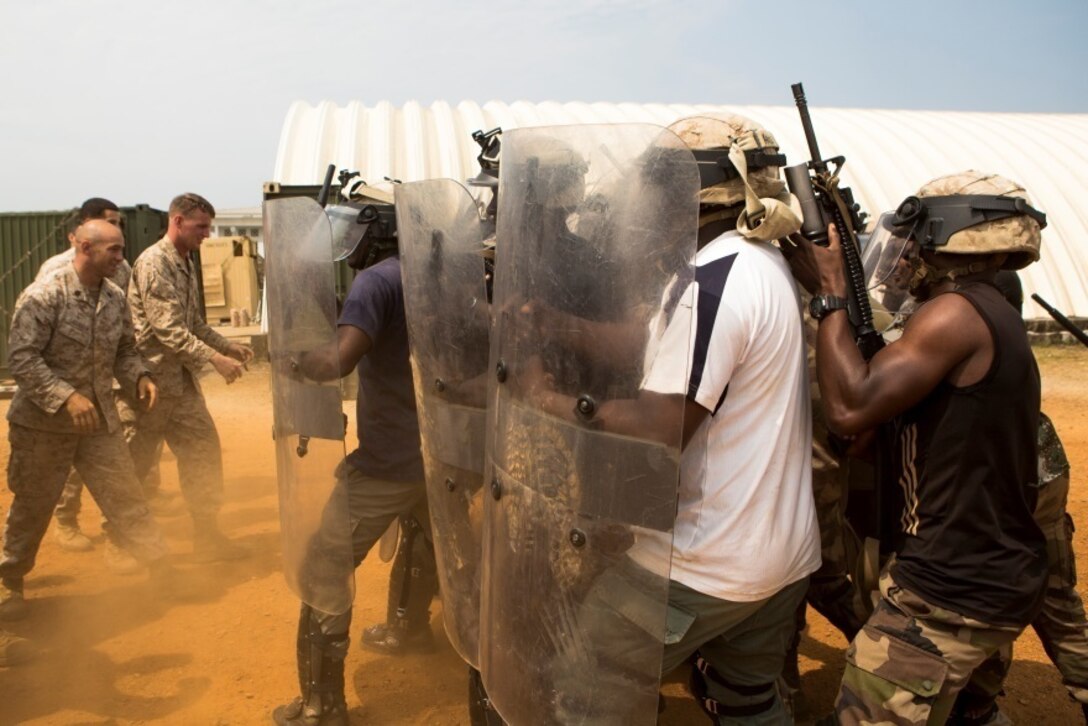 Gabonese Gendarmerie service members demonstrate their riot and crowd control techniques at a Cooperative Security Location established by U.S. Marines with Special-Purpose Marine Air-Ground Task Force Crisis Response-Africa in Libreville, Gabon, June 24, 2015. The Gabonese Gendarmerie unit is tasked with containing riots and even responding to situations that may occur outside the nearby embassy. The service members with SPMAGTF-CR-AF, which is based out of Morón Air Base, Spain, are currently validating their forward-staging capabilities while building partnerships with their Gabonese counterparts. (U.S. Marine Corps photograph by Lance Cpl. Christopher Mendoza/Released)