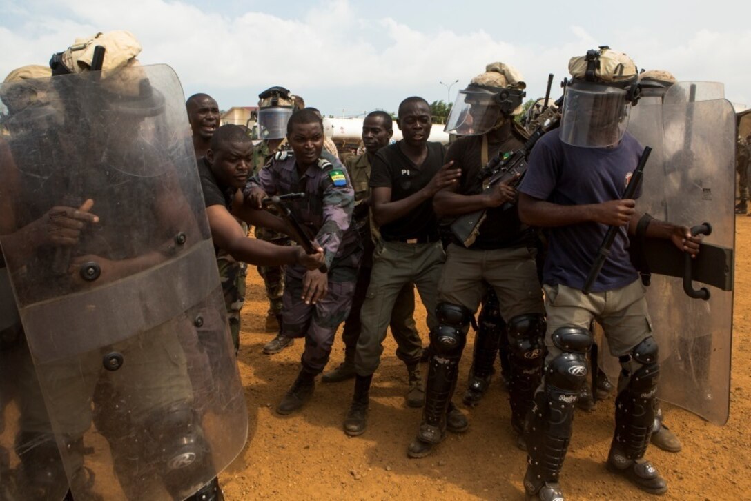 Gabonese Gendarmerie service members demonstrate their riot and crowd control techniques at a Cooperative Security Location established by U.S. Marines with Special-Purpose Marine Air-Ground Task Force Crisis Response-Africa in Libreville, Gabon, June 24, 2015. The Gabonese Gendarmerie unit is tasked with containing riots and even responding to situations that may occur outside the nearby embassy. The service members with SPMAGTF-CR-AF, which is based out of Morón Air Base, Spain, are currently validating their forward-staging capabilities while building partnerships with their Gabonese counterparts. (U.S. Marine Corps photograph by Lance Cpl. Christopher Mendoza/Released)