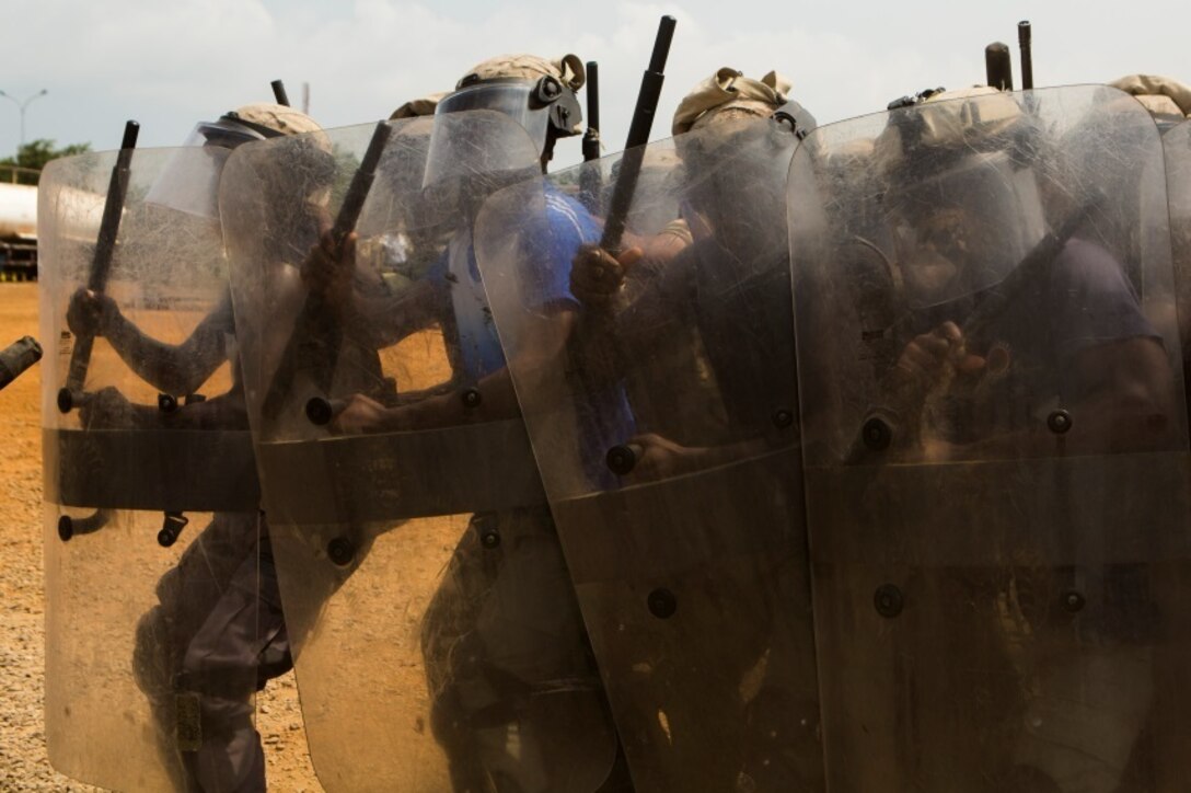 Gabonese Gendarmerie service members demonstrate their riot and crowd control techniques at a Cooperative Security Location established by U.S. Marines with Special-Purpose Marine Air-Ground Task Force Crisis Response-Africa in Libreville, Gabon, June 24, 2015. The Gabonese Gendarmerie unit is tasked with containing riots and even responding to situations that may occur outside the nearby embassy. The service members with SPMAGTF-CR-AF, which is based out of Morón Air Base, Spain, are currently validating their forward-staging capabilities while building partnerships with their Gabonese counterparts. (U.S. Marine Corps photograph by Lance Cpl. Christopher Mendoza/Released)