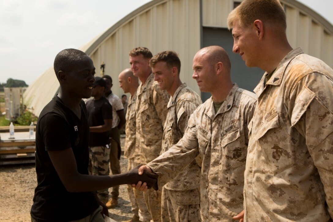 A Gabonese Gendarmerie service member shakes hands with U.S. service members from Special-Purpose Marine Air-Ground Task Force Crisis Response-Africa after receiving a certificate for participating in a non-lethal weapons training course at the unit’s Cooperative Security Location in Libreville, Gabon, June 24, 2015. The Gabonese Gendarmerie unit is tasked with containing riots and even responding to situations that may occur outside the nearby embassy. The service members with SPMAGTF-CR-AF, which is based out of Morón Air Base, Spain, are currently validating their forward-staging capabilities while building partnerships with their Gabonese counterparts. (U.S. Marine Corps photograph by Lance Cpl. Christopher Mendoza/Released)