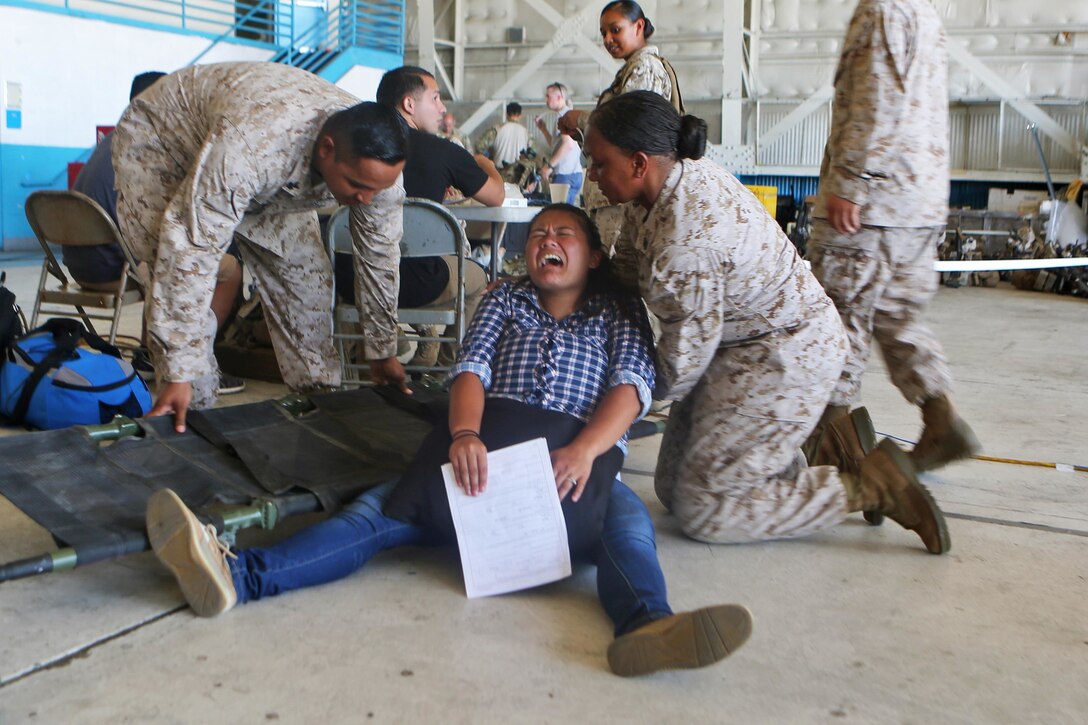 Navy medical personnel with Combat Logistics Group 6, provide aid to an American citizen going into labor at the evacuation command center during a simulated embassy evacuation aboard Naval Air Station Oceana, Va. The ECC is part of a week-long Special Purpose Marine Air Ground Task Force - Crisis Response- Africa certification exercise, the final step in the pre-deployment training. (U.S. Marine Corps photo by Staff Sgt. Vitaliy Rusavskiy/ Released)