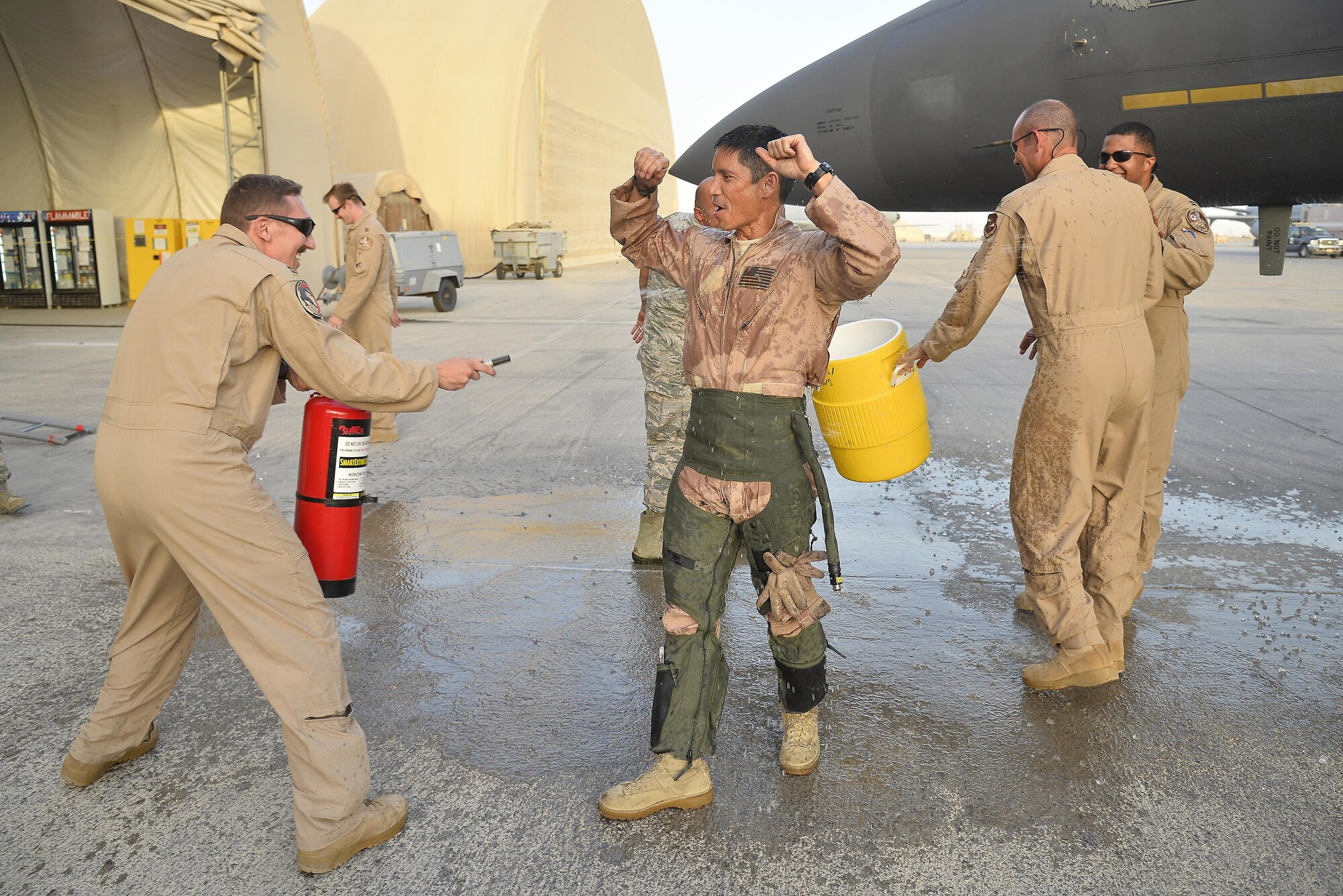 Brig. General John T. Quintas celebrates with members of the Air Expeditionary Wing after completing his fini flight at an undisclosed location in Southwest Asia June 25, 2015. Quintas is a master navigator and the commander of the Air Expeditionary Wing. (U.S. Air Force photo/Tech. Sgt. Christopher Boitz)