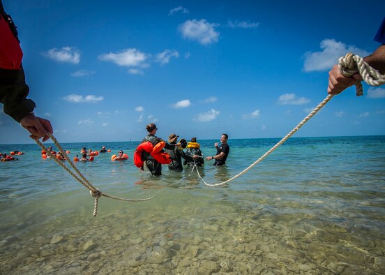 Airmen prepare to conduct a body drag during a water survival exercise June 27, 2015, at Naval Air Station Key West, Fla. More than 90 Airmen from the 300th Airlift Squadron deployed for a mass exercise that involved accomplished more than 500 training tasks. (U.S. Air Force photo by Senior Airman Tom Brading)