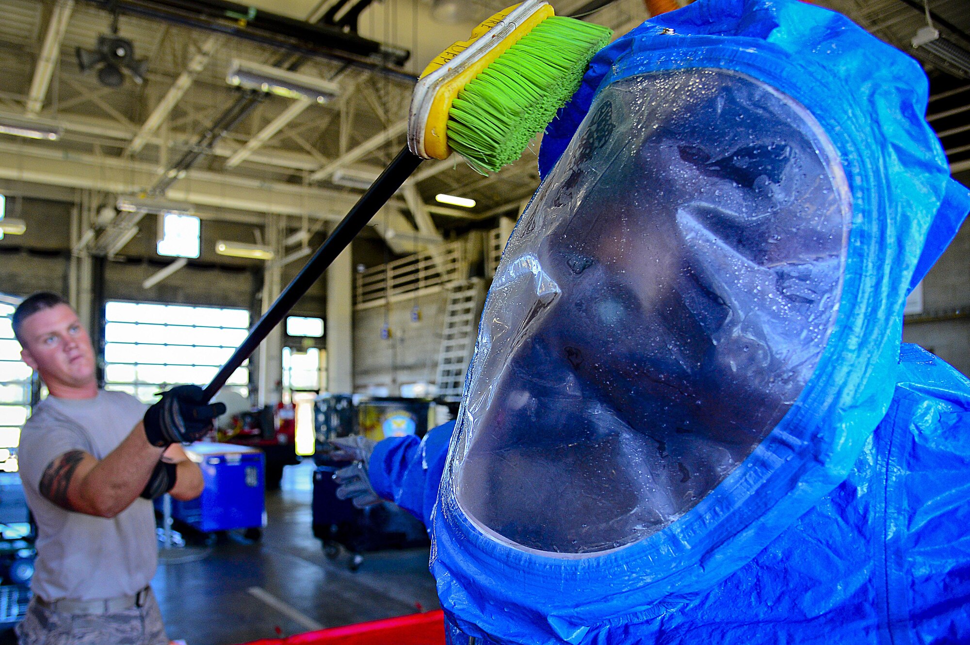 A 6th Civil Engineering Squadron fire fighter scrubs an Airmen in a Level A hazardous material suit during a joint responder training at MacDill Air Force Base, Fla., June 24, 2015. The HAZMAT decontamination line ensures that all personnel leaving the hazardous material “hot zone” are properly cleaned of any and all contaminants. (U.S. Air Force photo by Senior Airman Ned T. Johnston)
