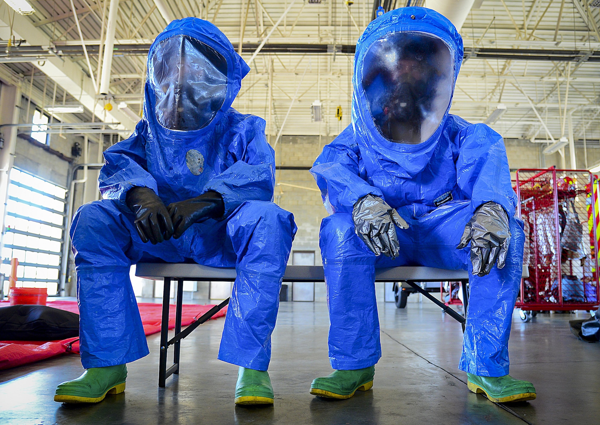 Two 6th Civil Engineering fire fighters prepare to go through a hazardous material decontamination line at MacDill Air Force Base, Fla., June 24, 2015. The joint responder training that involved many on-base agencies started with a classroom refresher followed by the decontamination line. (U.S. Air Force photo by Senior Airman Ned T. Johnston)