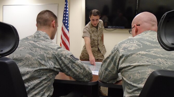 U.S. Marine Corps 1st Lt. Samuel Winsted, F-35B Lightning II intelligence officer, provides a mock intelligence briefing to two instructors during the F-35 Intelligence Formal Training Unit course, June 17, 2015, on Eglin Air Force Base, Florida. Winsted will serve in a critical role assisting the Marine Corps’ F-35 program at Marine Corps Air Station Yuma, Arizona, as it becomes the first operational F-35B base. The Marine Corps will declare IOC with the F-35B, short take-off and vertical landing variant, this summer. (U.S. Air Force photo/Staff Sgt. Marleah Robertson)