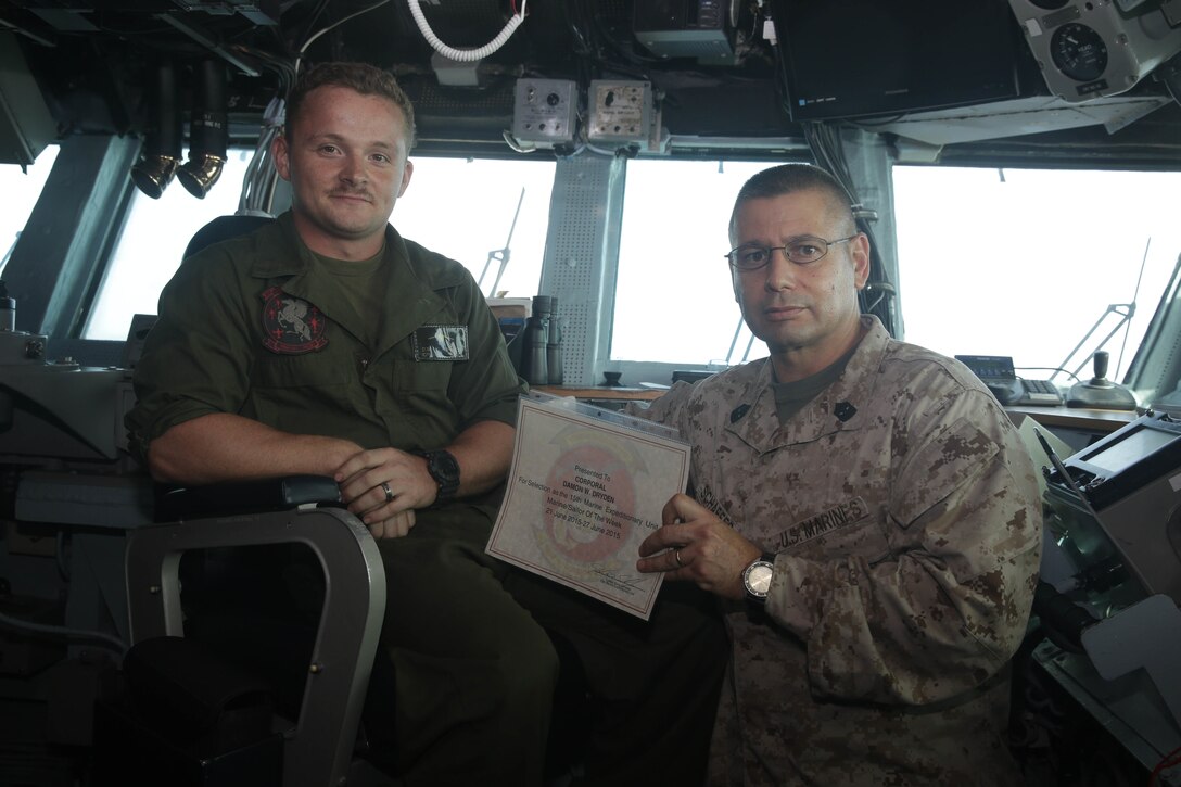 ARABIAN SEA (June 26, 2015) U.S. Marine Sgt. Maj. Douglas Schaefer, right, presents the 15th Marine Expeditionary Unit “Marine of the Week” award to Cpl. Damon Dryden aboard the USS Essex (LHD 2). Schaefer is the sergeant major of the 15th MEU and Dryden is an AV-8B Harrier airframes mechanic with Marine Medium Tiltrotor Squadron 161 (Reinforced), 15th MEU, from Jeffersonville, Indiana. Dryden’s maintenance work ethic, leadership and knowledge are apparent throughout his shop and contagious among the Marines he mentors and works with. He is a collateral duty instructor and supervises safe maintenance practices during day-to-day maintenance tasks and has signed off on a total of 51 jobs totaling over 400 man-hours. He also worked tirelessly during two phase maintenance evolutions pulling a wing and engine to facilitate additional maintenance troubleshooting. The 15th MEU is embarked on the Essex Amphibious Ready Group and deployed to maintain regional security in the U.S. 5th Fleet area of operations. (U.S. Marine Corps photo by Cpl. Anna Albrecht/Released)