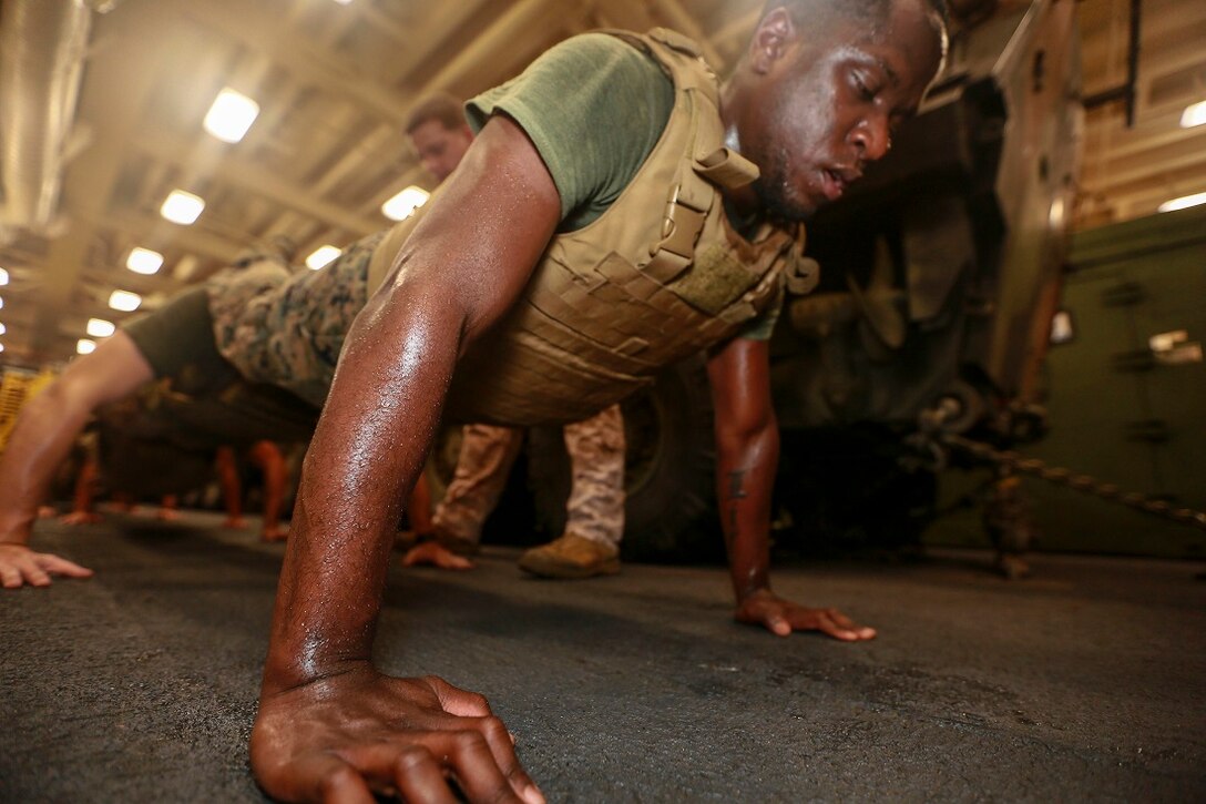 ARABIAN SEA (June 24, 2015) U.S. Marine Cpl. Million Sudler conducts squad push-ups during a Martial Arts Instructor Course aboard the USS Anchorage (LPD 23).  Sudler is a rifleman with Battalion Landing Team 3rd Battalion, 1st Marine Regiment, 15th Marine Expeditionary Unit. The students are going through the rigorous course in order to become MCMAP instructors for their respective units. Anchorage is part of the Essex Amphibious Ready Group and, with the embarked 15th MEU, is deployed in support of maritime security operations and theater security cooperation efforts in the U.S. 5th Fleet area of operations. (U.S. Marine Corps photo by Sgt. Jamean Berry/Released)