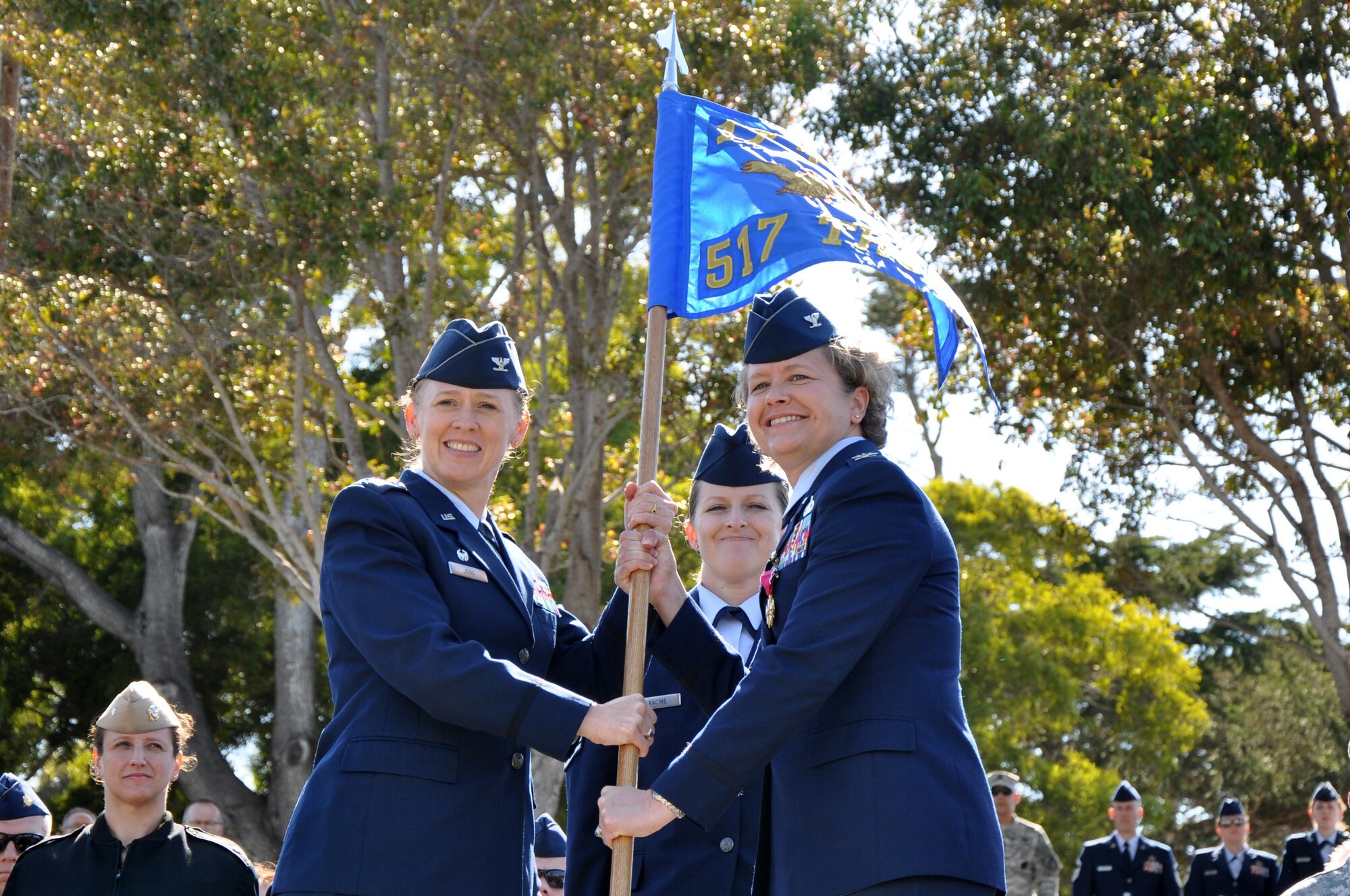 U.S. Air Force Col. Ginger L. Wallace, 517th Training Group Commander, passes the guidon to Col. Kimberlee P. Joos, 17th Training Wing Commander during the 517th TRG change of command ceremony at the Presidio of Monterey, California, June 26, 2015. Col. Keith M. Logeman assumed command of the 517th TRG as the incoming commander. (U.S. Air Force photo by Senior Airman Joshua Edwards/ released)