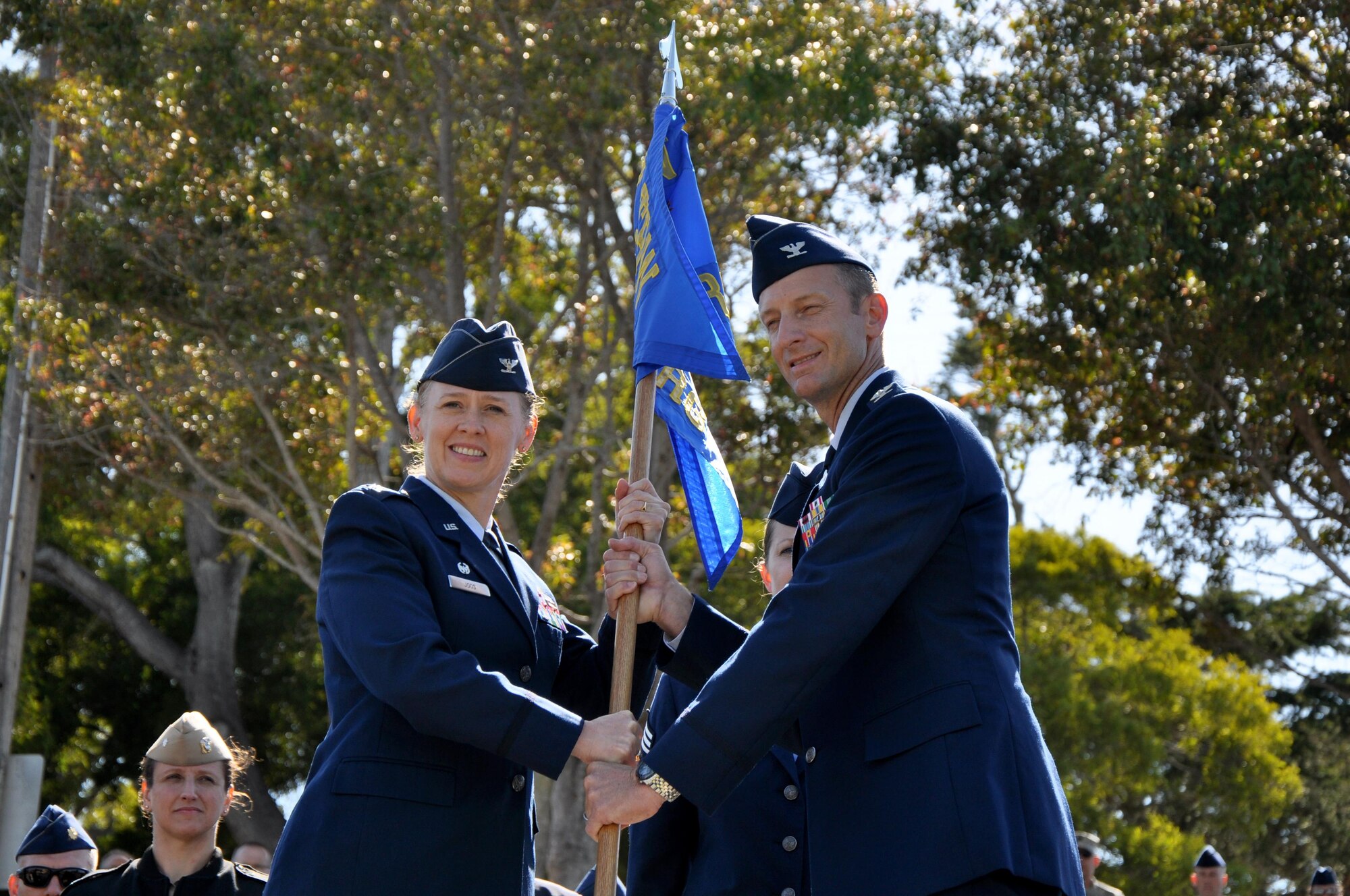 U.S. Air Force Col. Kimberlee P. Joos, 17th Training Wing Commander, passes the 517th Training Group guidon to Col. Keith M. Logeman during the 517th TRG change of command ceremony at the Presidio of Monterey, California, June 26, 2015. Logeman said he has three goals for the 517th TRG: improve the mission, focus on Airmanship programs and help take care of Airmen’s families. (U.S. Air Force photo by Senior Airman Joshua Edwards/ released)