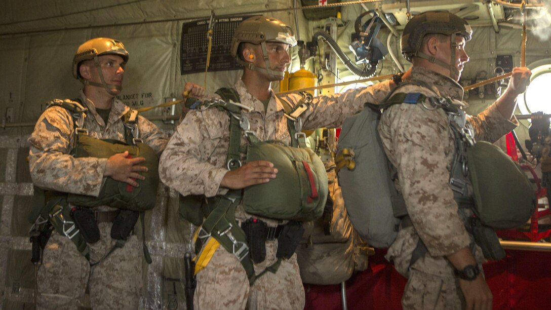 Marines with 2nd Reconnaissance Battalion, 2nd Marine Division, prepare to jump from a C130J during intentional water training at Marine Corps Base Camp Lejeune, North Carolina June 24, 2015. Marines used hand signals to communicate what actions need to be performed prior to leaping from the aircraft.