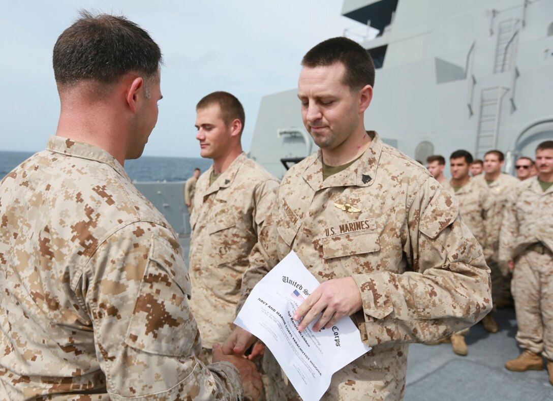 U.S. Marine Gunnery Sgt. Mickey Eaton, right, pins gold jump wings onto Sgt. Barrett McKibben aboard the USS Anchorage (LPD 23) in the Indian Ocean, June 19, 2015. Eaton and McKibben are both with the Force Reconnaissance Detachment, 15th Marine Expeditionary Unit. Marines go through intense training to earn their gold jump wings. (U.S. Marine Corps photo by Sgt. Steve H. Lopez/Released)