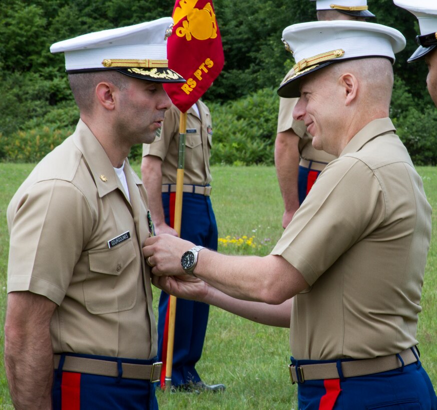Major Andrew Gourgoumis, outgoing commanding officer of Recruiting Station Portsmouth, New Hampshire, receives an award from Col. James Iulo, commanding officer of 1st Marine Corps District, following his passing of command during the change of command ceremony, June 26. Major Stephen Boada, the new commanding officer, is coming from his position as inspector-instructor of Battery P., 5th Battalion, 14th Marines in Spokane, Washington, and Gourgoumis is heading to the Command and Staff College aboard Marine Corps Base Quantico, Virginia.