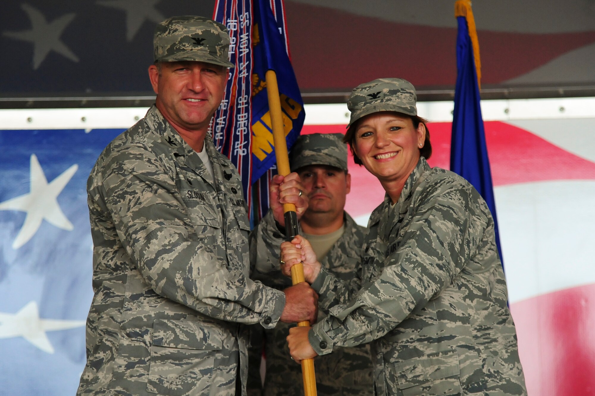 Col. Eleanor Nazar-Smith (right), outgoing 4th Medical Group commander, relinquishes the guidon to Col. Mark Slocum, 4th Fighter Wing commander, during a change of command ceremony, June 25, 2015, at Seymour Johnson Air Force Base, North Carolina. Nazar-Smith led the group for two years and will retire after relinquishing command. (U.S. Air Force photo/Senior Airman Brittain Crolley)