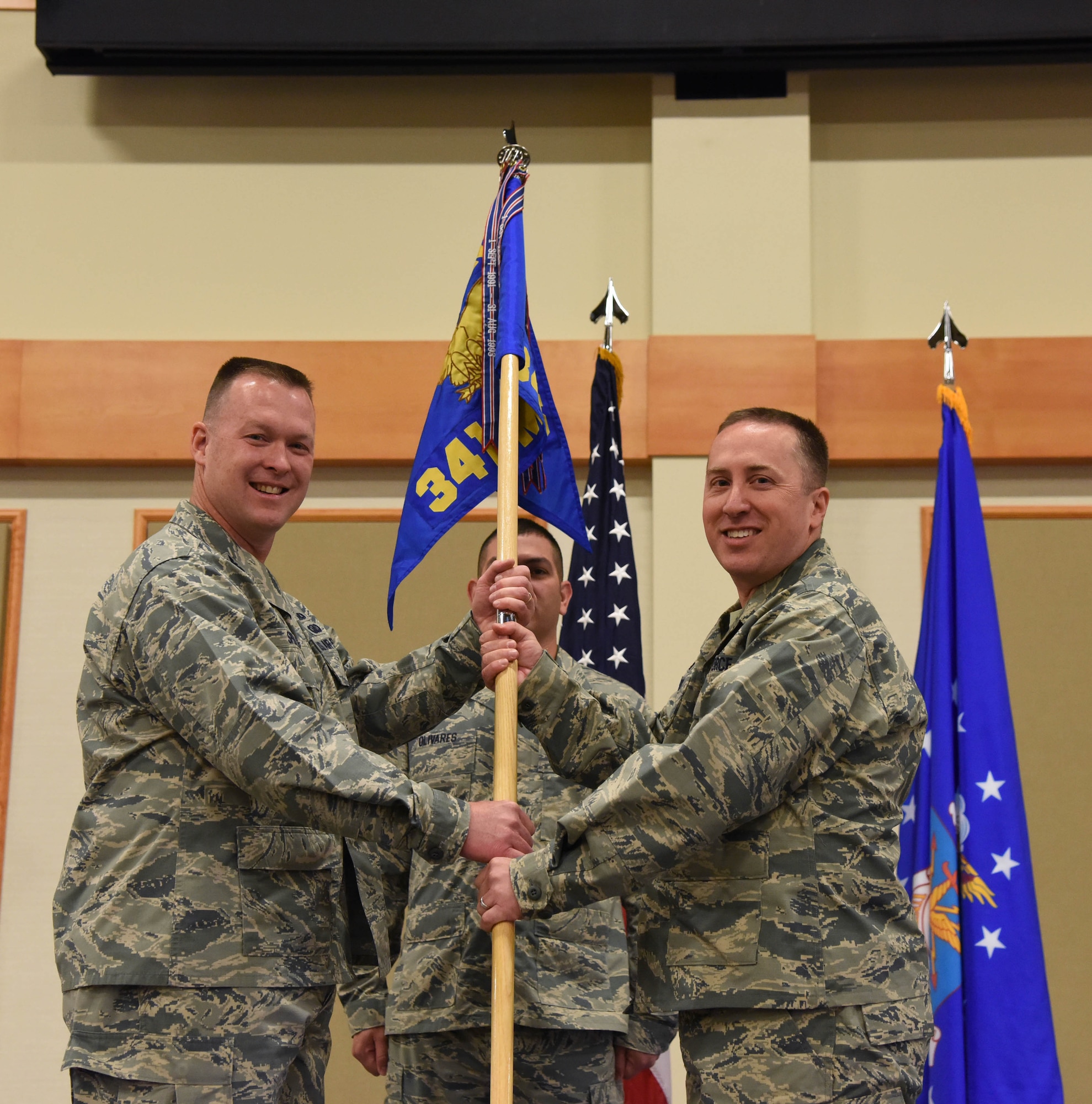 Maj. James Spoo, right, accepts command of the 341st Maintenance Operations Squadron from Col. Kenneth Speidel, 341st Maintenance Group commander, June 19 at the Grizzly Bend as Malmstrom Air Force Base, Mont. Master Sgt. Daniel Olivares, 341st MOS first sergeant, looks on. (U.S. Air Force photo/Airman 1st Class Collin Schmidt) 