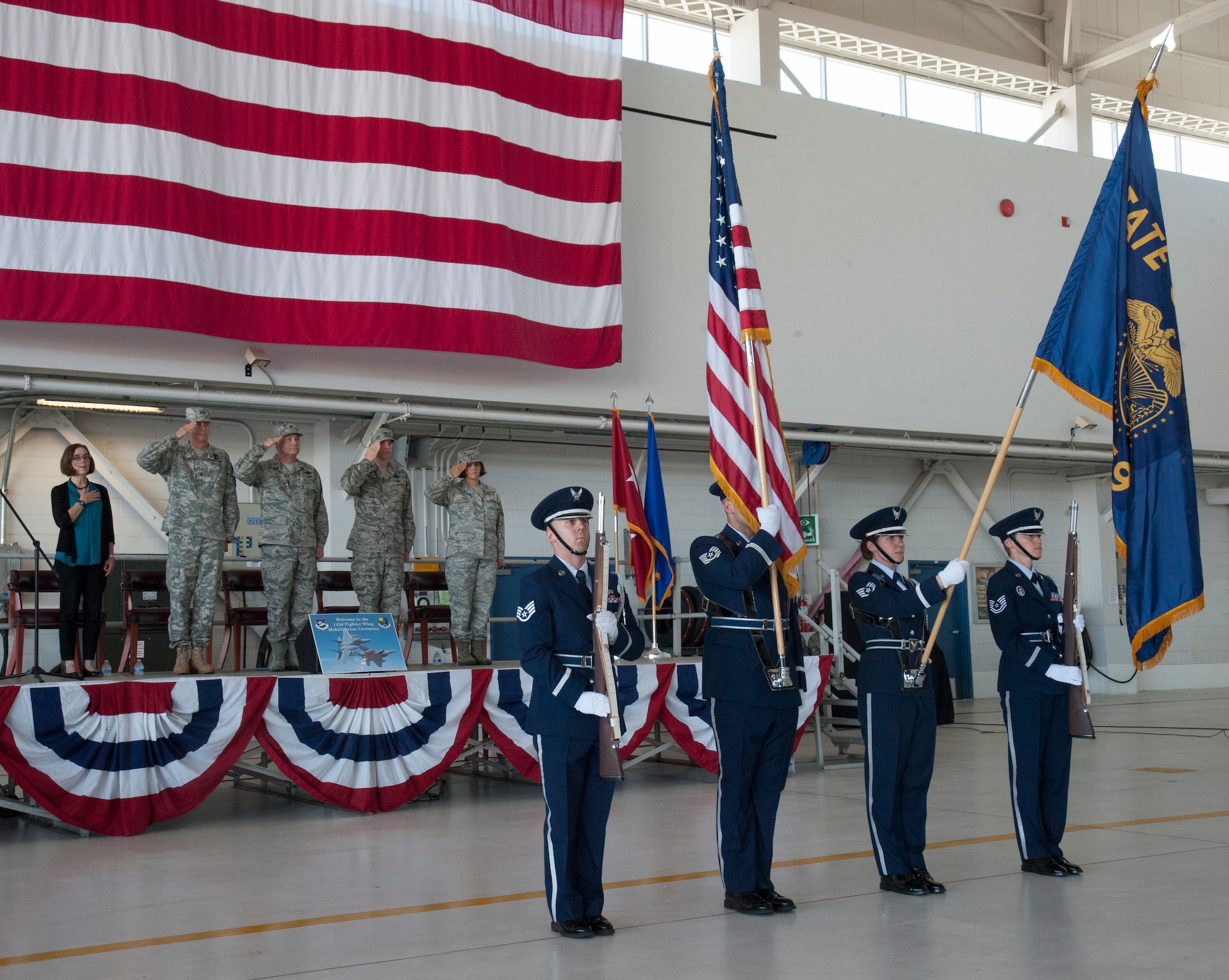 Members of the official party render honors to the colors of the American and State of Oregon flags presented by the 142nd Fighter Wing Base Honor Guard during the formal mobilization ceremony June 26, 2015, Portland Air National Guard Base, Ore. (U.S. Air National Guard photo by Tech. Sgt. John Hughel, 142nd Fighter Wing Public Affairs/Released)