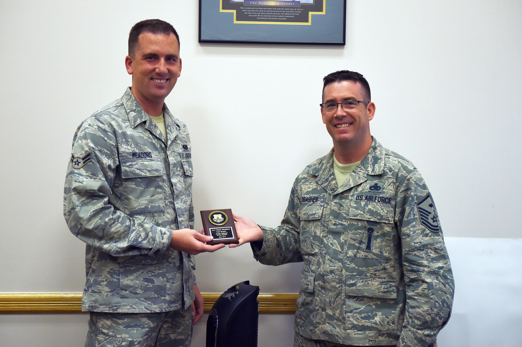 Airman 1st Class Mark Meadors, 460th Space Wing customer service technician, is awarded the Junior Enlisted of the Month award June 29, 2015, on Buckley Air Force Base, Colo. The JEoM award is given to the most deserving Airmen who have not only shown hard work, supreme leadership and dedication to their job, but also put forth significant effort into bettering themselves and the community. (U.S. Air Force photo by Airman 1st Class Emily E. Amyotte/Released)