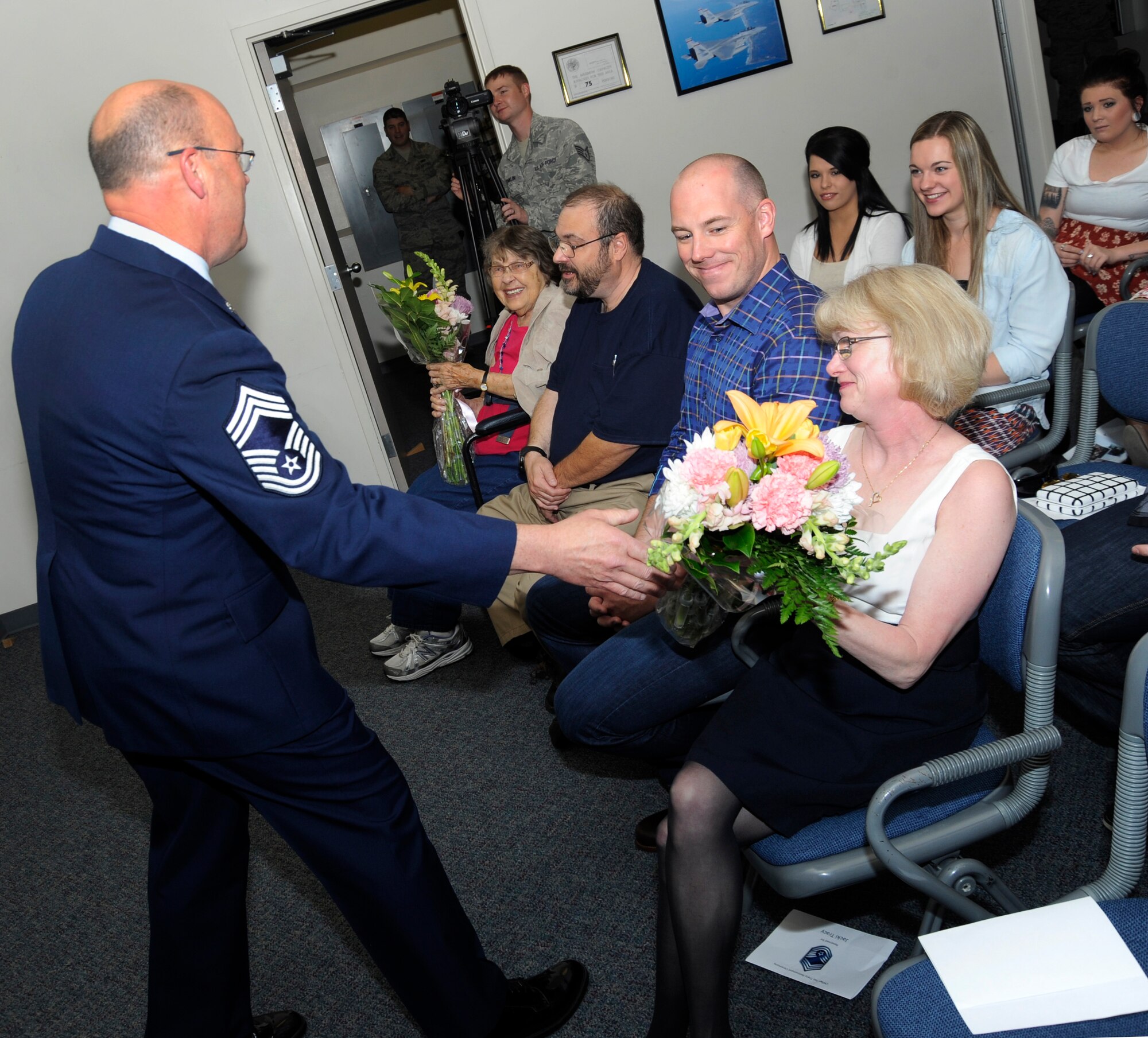 Oregon Air National Guard Chief Master Sgt. Patrick Tracy present flowers to his mother and wife during his retirement ceremony, May 2, 2015, Portland Air National Guard Base, Ore. Tracy was assigned to the 142nd Fighter Wing Operations Group, serving as the senior enlisted leader and also was the Team Chief for the Air National Guard’s F-15 Eagle Weapons System Council, Aircrew Flight Equipment. (U.S. Air National Guard by Tech. Sgt. John Hughel, 142nd Fighter Wing Public Affairs Department)