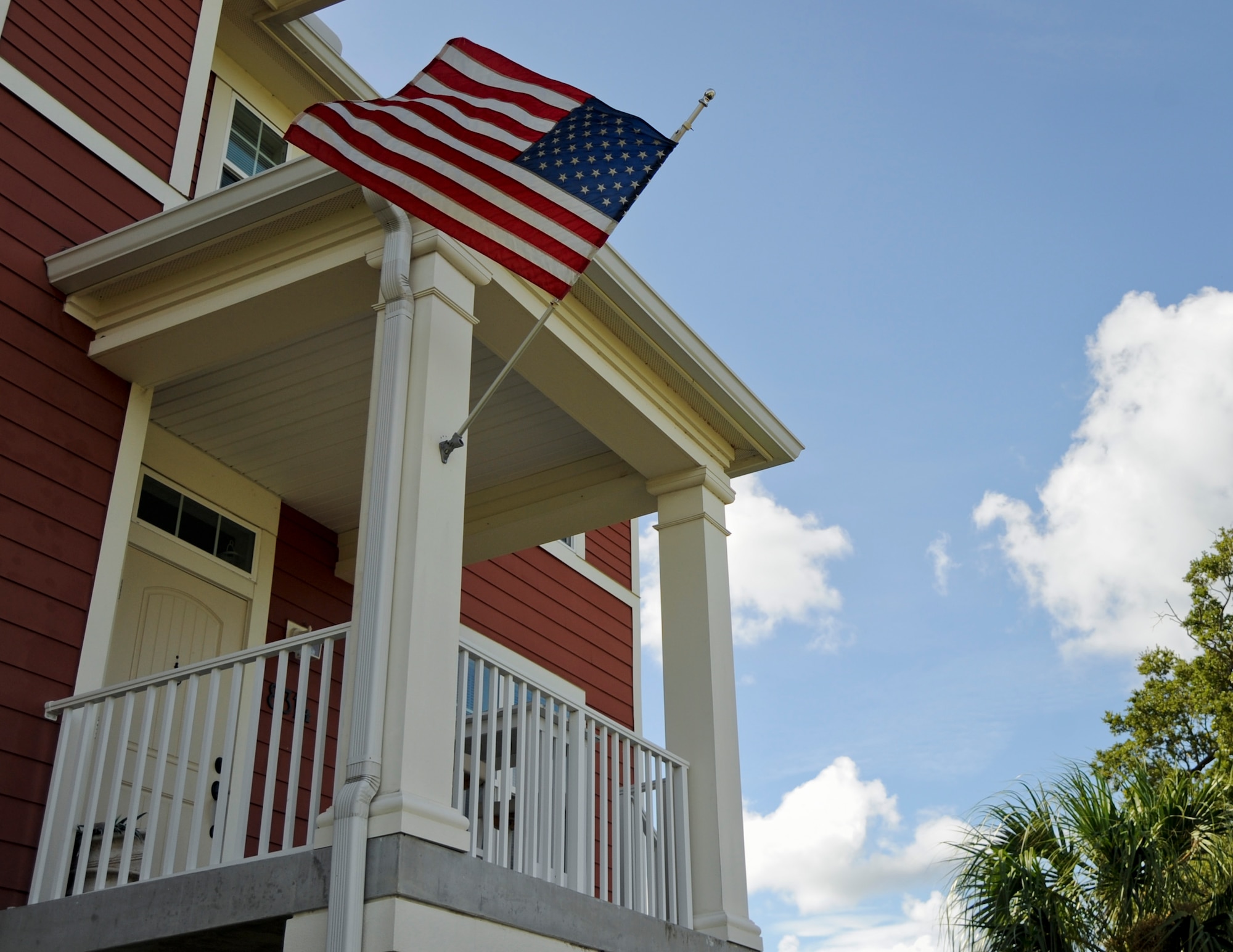 An American flag waves in the wind in front of a resident’s house at MacDill Air Force Base, Fla., June 29, 2015. It is important that the entire flag is visible when being displayed and free to wave without any obstructions. (U.S. Air Force photo by Airman 1st Class Danielle Conde/Released)