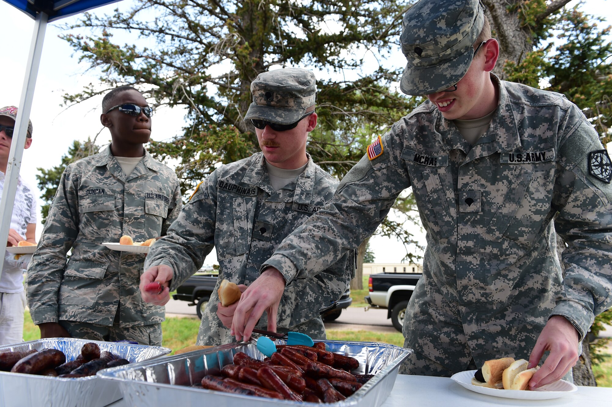 Junior enlisted Team Buckley members grab some food during the Junior Enlisted Appreciation Day celebration June 29, 2015, at the all-purpose field on Buckley Air Force Base, Colo. Junior Enlisted Appreciation Day is held annually to recognize the efforts of E-4s and below on Buckley AFB. (U. S. Air Force photo by Airman 1st Class Luke W. Nowakowski/Released)