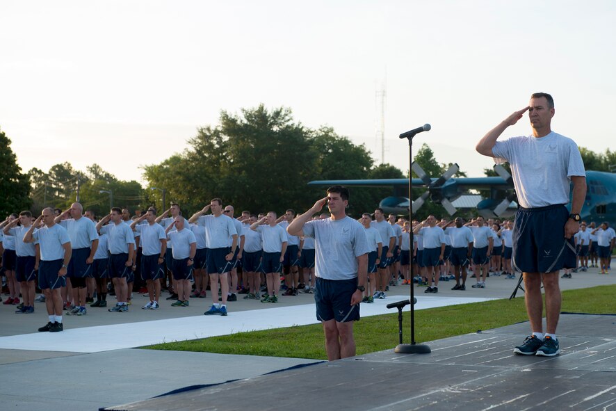 U.S. Air Force Col. Chad Franks, 23d Wing commander, along with members of Team Moody render salutes during reveille June 26, 2015, at Moody Air Force Base, Ga. Airmen participated in the 2.3-mile Wing warrior run to promote morale and physical fitness. (U.S. Air Force photo by Airman 1st Class Kathleen D. Bryant/Released)