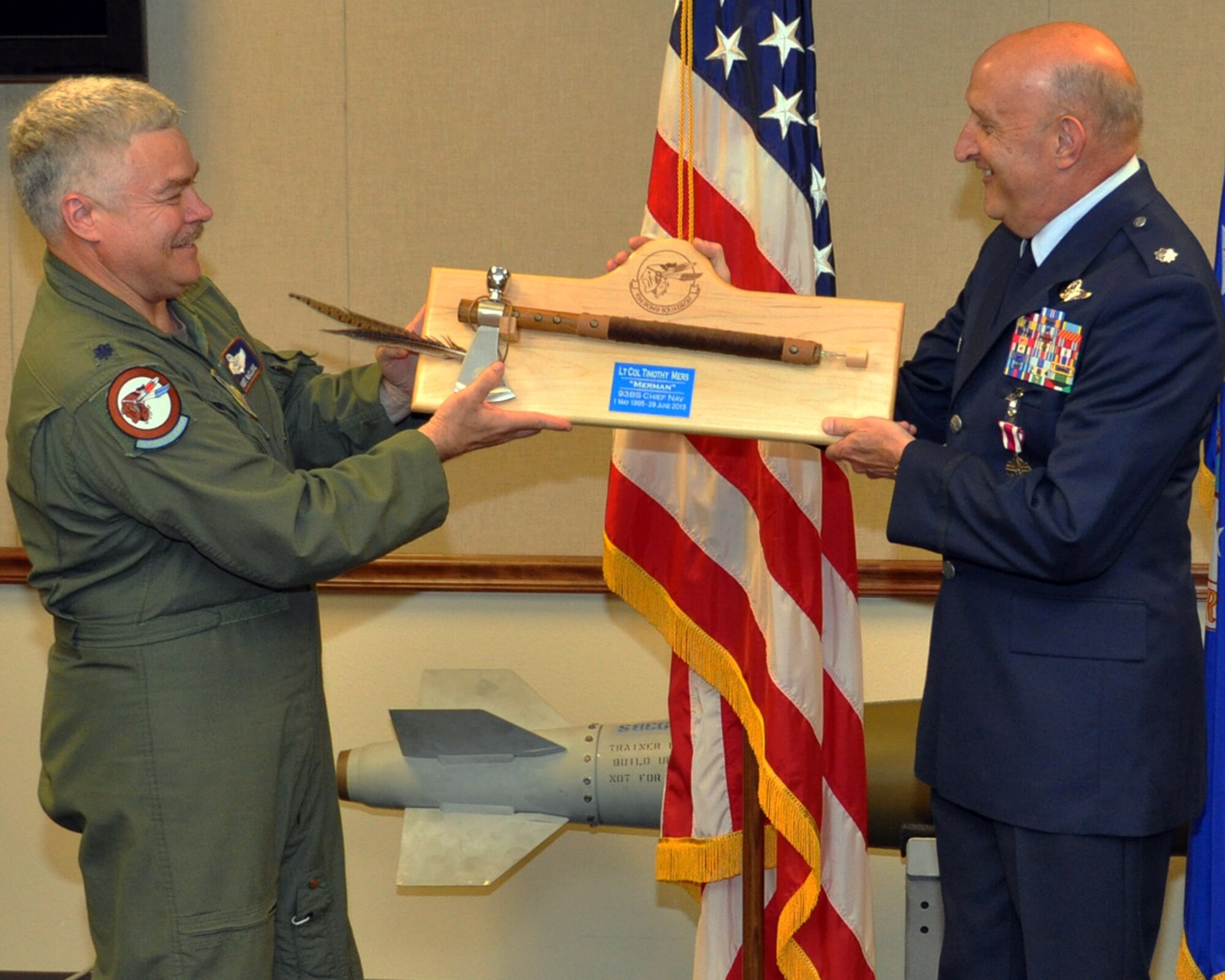 U.S. Air Force Lt. Col. Kurt McClure presents a plaque to Lt. Col. Tim Mers commemorating his service while assigned to the 93rd Bomb Squadron during a retirement ceremony on June 26, 2015, Barksdale Air Force Base, La.  Colonel Mers is retiring from the U.S. Air Force Reserve with over 30 years of service and over 7,000 flying hours. (U.S. Air Force photo by Master Sgt. Laura Siebert/Released)