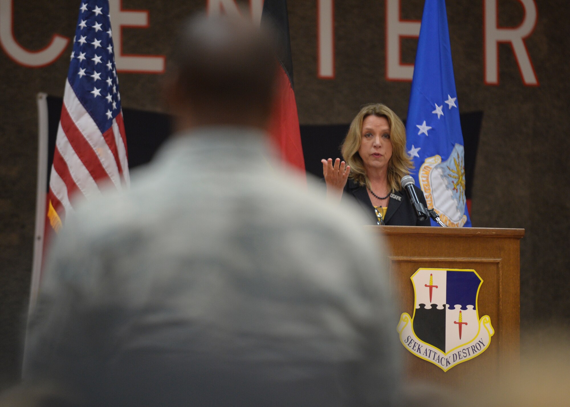 Deborah Lee James, Secretary of the U.S. Air Force, speaks about the cost-saving initiatives made by U.S. Air Force Tech. Sgt. Kenyatta Clemons, 52nd Logistics Readiness Squadron phase support technician, during an all-call at the Skelton Memorial Fitness Center at Spangdahlem Air Base, Germany, June 23, 2015. James highlighted Clemons’ suggestion of a single room to obtain and dispose cleaning supplies as a means of reducing costs and man hours while raising efficiency as part of the U.S. Air Forces’ Make Every Dollar Count initiative. The Secretary completed a visit of installations through Europe June 24, 2015, to meet Airmen, community leaders and allied and partner nation defense chiefs. (U.S. Air Force photo by Staff Sgt. Joe W. McFadden/Released)